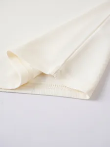Nahaufnahme von cremefarbenem Piqué-Stoff und Nähten an einem Herren-Poloshirt.