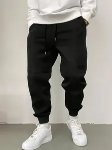 Μπροστινή όψη μαύρης ανδρικής φόρμας streetwear με κορδόνι και στενό τελείωμα