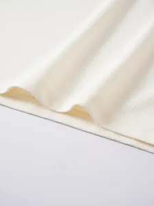 Makrodetail des weißen Waffelstrickstoffs am Herren-Poloshirt mit sehr feinen Nähten.