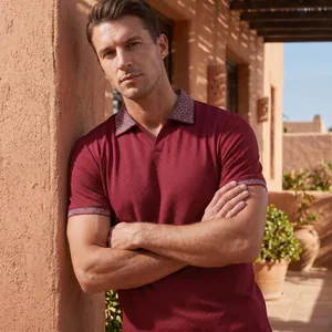 Detail des weinroten Herren-Poloshirts mit gemustertem Kragen im warmen Sonnenlicht