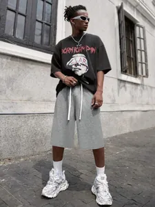 Pantaloncini grigi stile street da uomo con coulisse indossati da un modello all'aperto