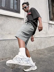 Dettaglio street style di pantaloncini casual da uomo grigio tinta unita indossati da un modello