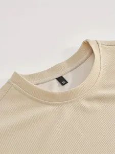 Primo piano della trama a nido d'ape e dello scollo a costine di una t-shirt sportiva beige