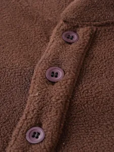 Detailopname van bruine fleece-textuur en knoopsluiting op een herensweatshirt
