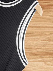 Close-up detail of black ribbed knit tank top with white striped trim and neat stitching.