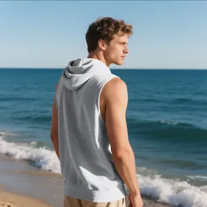 Modelo masculino con chaleco gris con capucha sin mangas sobre un fondo de playa
