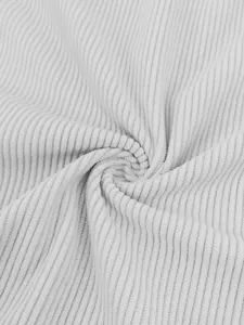 Macro view of white ribbed corduroy fabric showing soft texture and drape detail