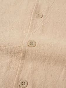 Gros plan sur le tissu en lin beige respirant avec boutons d'une chemise pour hommes.
