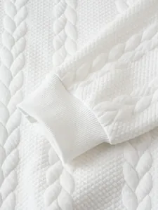 Gros plan d'un poignet de sweat-shirt blanc montrant le tissu matelassé texturé