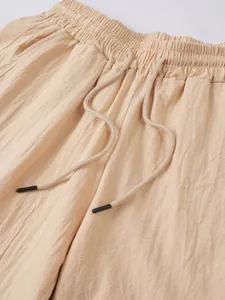 Détail en gros plan d'un pantalon en lin beige léger avec taille élastique et cordon de serrage