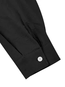 Detailed macro view of black cotton linen shirt cuff featuring a white resin button