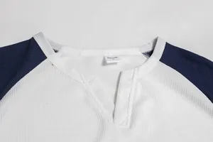 Detailansicht eines Waffelstrick-Raglan-Oberteils für Herren mit V-Ausschnitt und Patchwork.