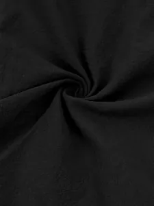 Macro detail shot of soft black cotton linen fabric with a natural woven texture.