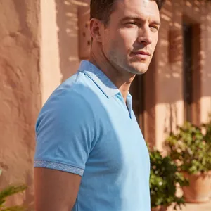 Nahaufnahme eines hellblauen Herren-Poloshirts mit geometrisch gemustertem Kragen