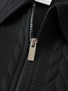 Détail du zip en métal argenté et de la texture matelassée d'un sweat-shirt noir pour hommes