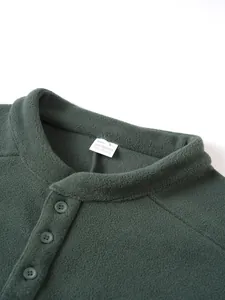 Detail van een donkergroen fleece sweatshirt voor heren met knopen en opstaande kraag.