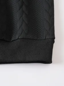 Gros plan d'un sweat-shirt noir pour homme montrant l'ourlet côtelé et le matelassage