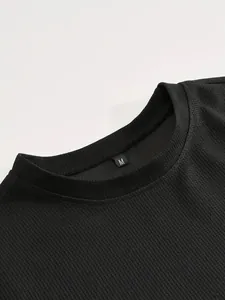 Dettaglio dello scollo di un top sportivo nero in maglia a nido d'ape con taglia M.