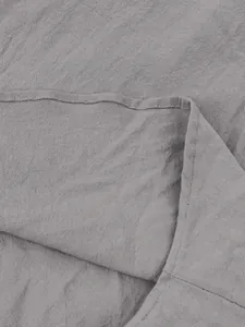 Close-up detail of grey cotton linen fabric and stitching on a men's casual Henley shirt.