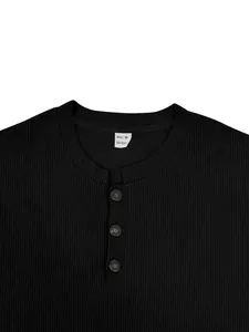 Detailed view of black ribbed corduroy shirt neckline featuring buttons and size tag