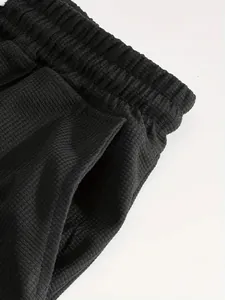 Vista dettagliata del tessuto a nido d'ape nero sulla fascia elastica e tasca sport