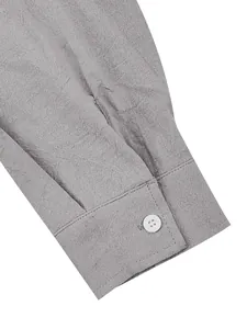 Close-up of the textured gray cotton linen shirt cuff showing fine stitching and button