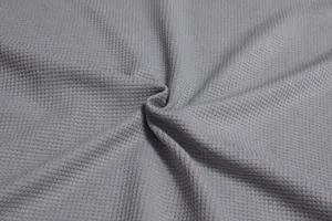 Detaillierte Makroansicht der weichen grauen Waffelstrick-Textur mit Gittermuster