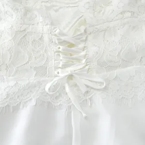 Close-up van het witte kanten lijfje met een delicaat strikdetail voor een elegante look