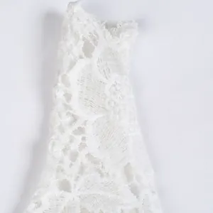 Close-up detail of delicate white floral lace embroidery texture on elegant evening dress