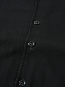 Vue macro détaillée montrant la texture du lin noir et les boutons d'une chemise homme