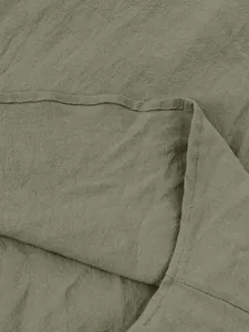 Close-up of olive green cotton linen fabric texture with clean stitching details.