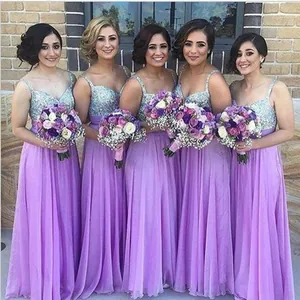 Grupo de cinco damas de honor con vestidos largos morados y lentejuelas brillantes