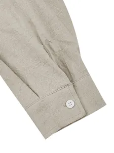 Close-up of a beach style linen shirt cuff with rustic texture and white button.