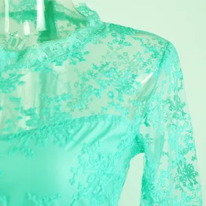 Nahaufnahme eines mintgrünen transparenten Spitzenkleides mit Blumenstickerei.