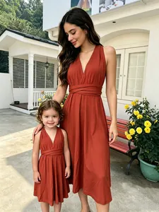 Madre e hija con vestidos infinity multiposición en color naranja teja al aire libre