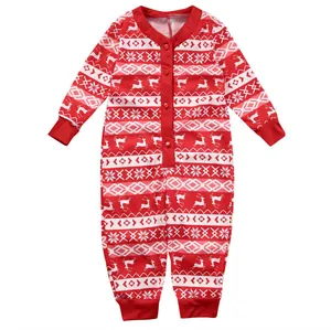 Detailweergave van feestelijk rendier- en sneeuwvlokpatroon op rode baby romper.