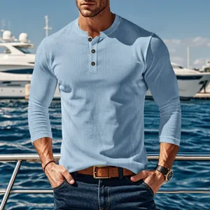 Detail of light blue ribbed long sleeve henley shirt for men with three-button neckline.
