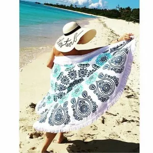 Serviette de plage ronde bohème avec imprimé mandala paon bleu et franges blanches.