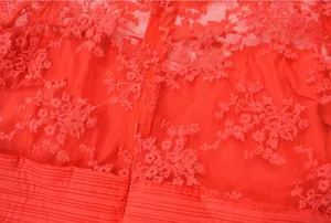 Detailansicht der aufwendigen Blumenstickerei auf rotem Netzstoff-Abendkleid
