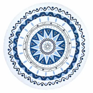 Vue détaillée d'une serviette de plage ronde à mandala bleu avec des glands blancs