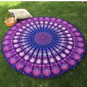 Serviette de plage ronde mandala avec motif paon bleu étalée sur de l'herbe verte
