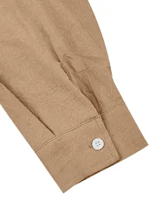 Detailed macro shot of a khaki cotton linen men's shirt cuff with a white button.