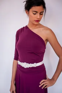 Close-up of a purple one-shoulder bandage dress with a sparkling rhinestone belt.