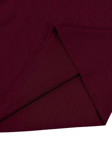 High-resolution macro view showing burgundy ribbed corduroy fabric texture and stitched hem detail