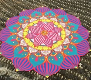 Serviette de plage mandala aux couleurs vives étalée sur une surface de galets naturels
