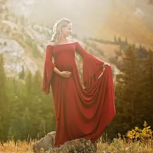 Détail d'une robe de maternité rouge à épaules dénudées pour la photographie.