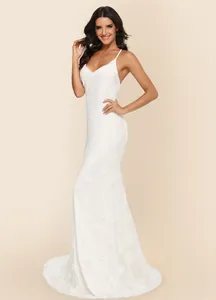 Side view detail of a white lace mermaid wedding dress with V-neck and long train.