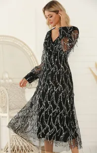 Detail view of a black V-neck sequined dress with silver fringe tassels on mesh fabric