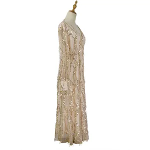 Elegant side view of long-sleeved sequined maxi dress featuring gold fringe details.