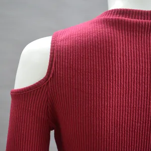 Detail macro view of maroon ribbed knit texture on cold-shoulder turtleneck sweater
